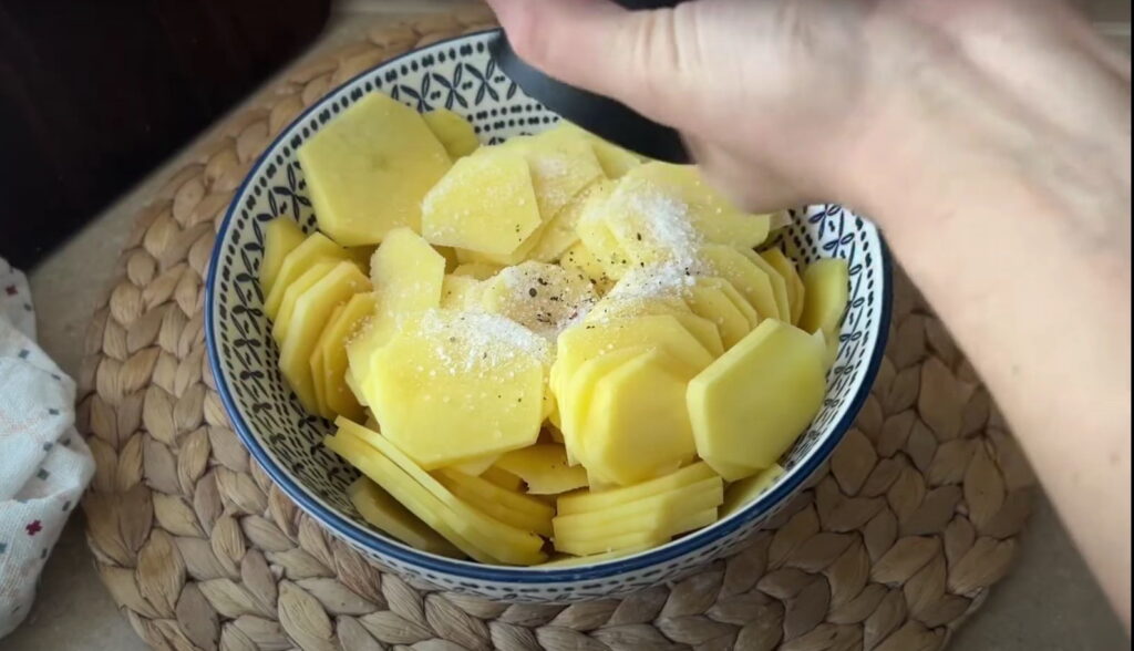 Насипання солі і перцю на сиру картоплю