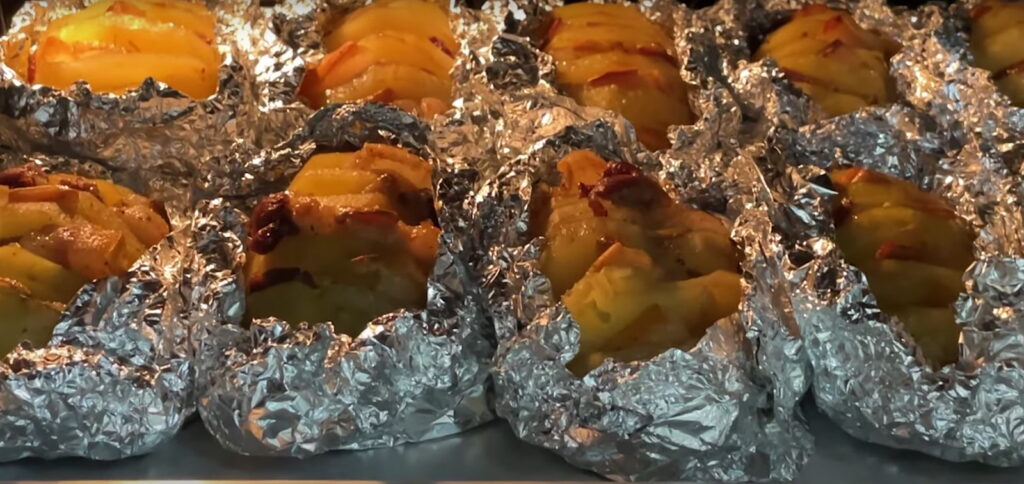 10 картоплин замотаних у фользі запікаються в печі