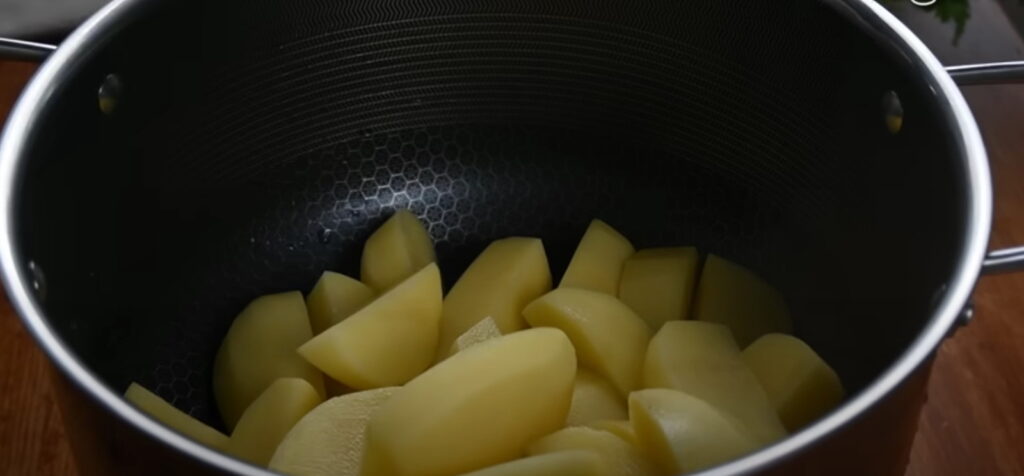 Сира картопля порізана дольками в каструлі