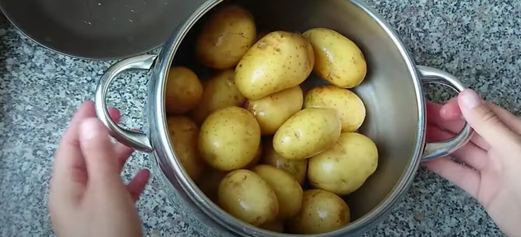 Ціла сира помита картопля зі шкіркою в каструлі