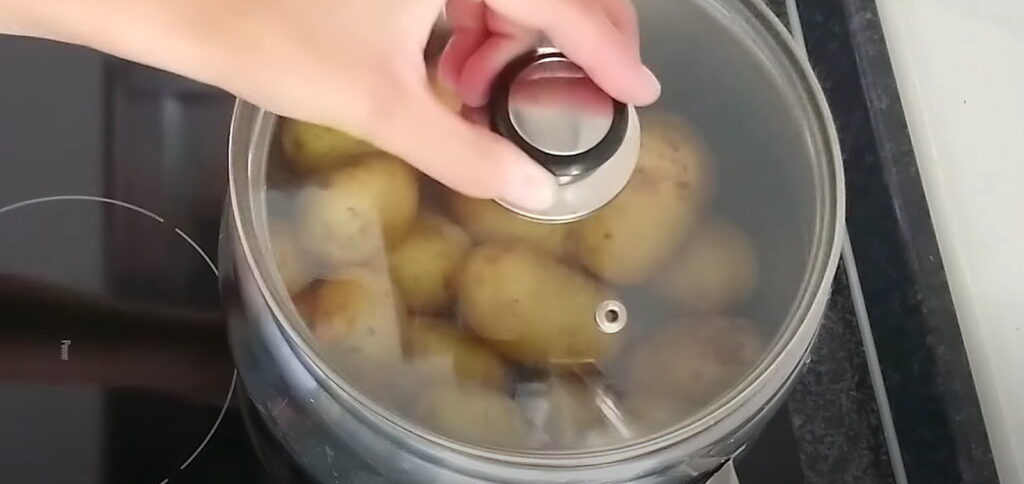 Варіння цілої картоплі зі шкіркою з накритою кришкою в каструлі