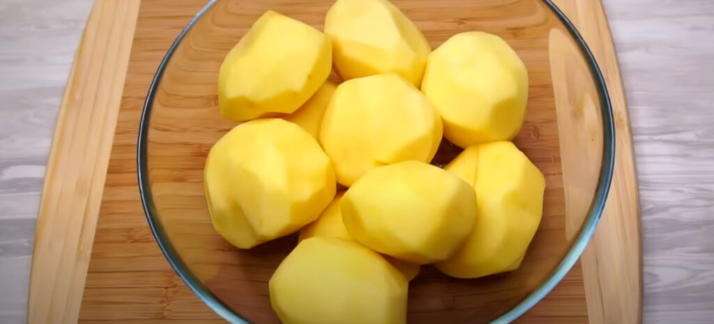 Велика сира картопля почищена цілою в скляній посудині 