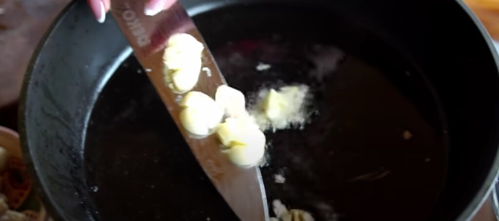 Часник викидається на сковорідку для подальшого обсмажування