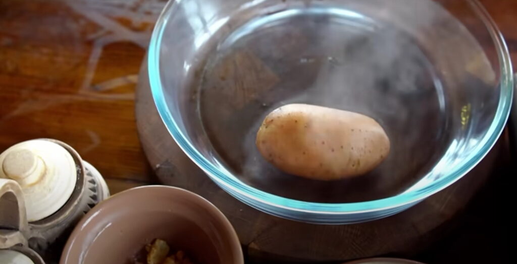 Ціла відварена картопля лежить у формі для запікання