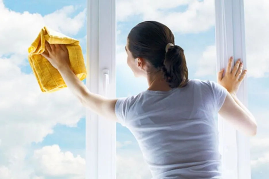 Жінка миє вікно під час генерального прибирання