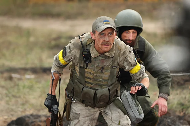 Двоє чоловіків посеред поля у військовій формі