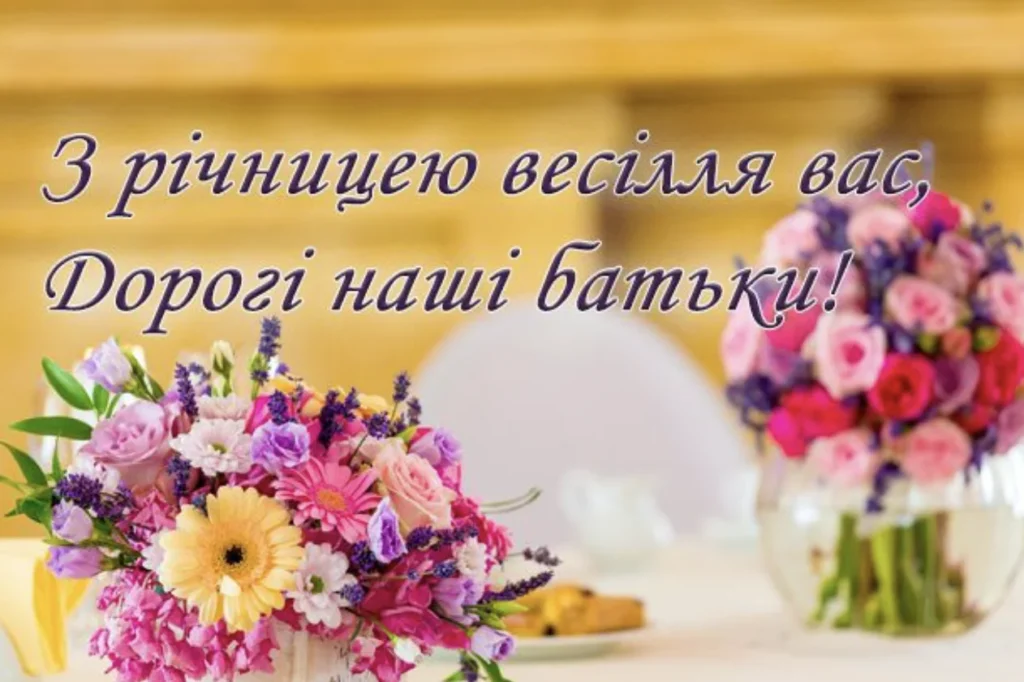 Привітання на фоні столу з букетами