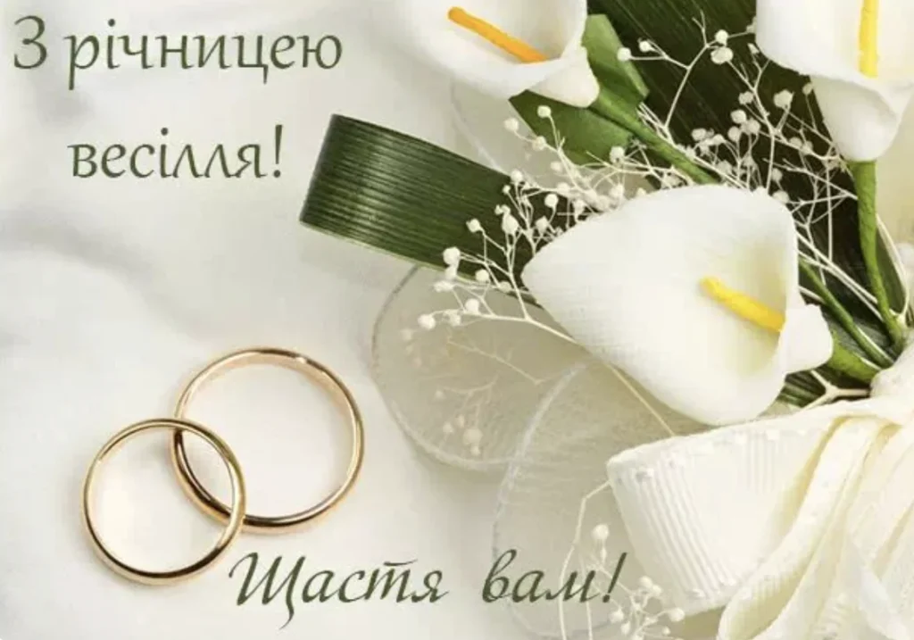 Дві обручки на білому фоні поруч із букетом